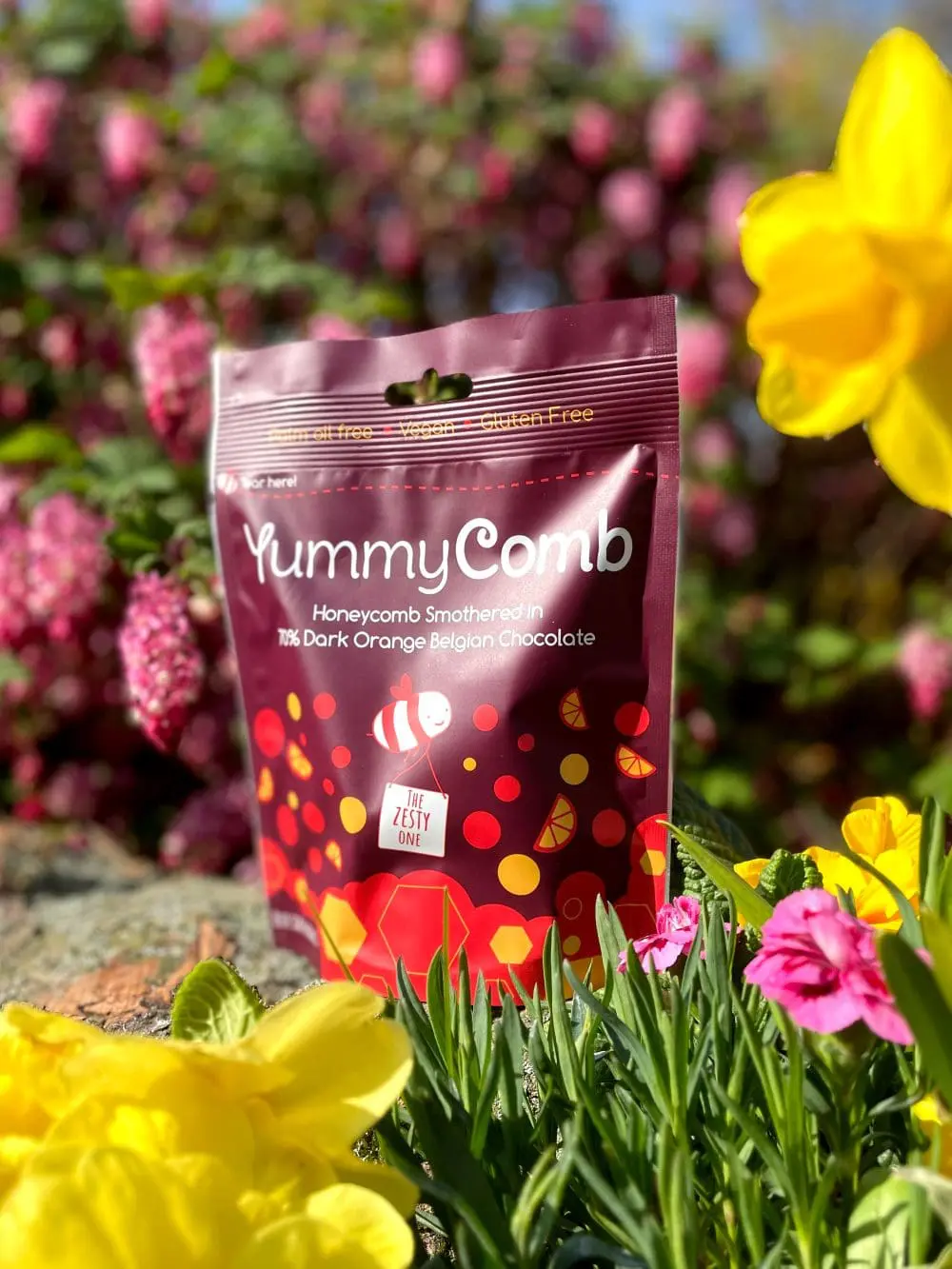 Yummcomb Dark Orange Belgian chocolate covered honeycomb nuggets in a sharing pouch bags 100g in a spring garden