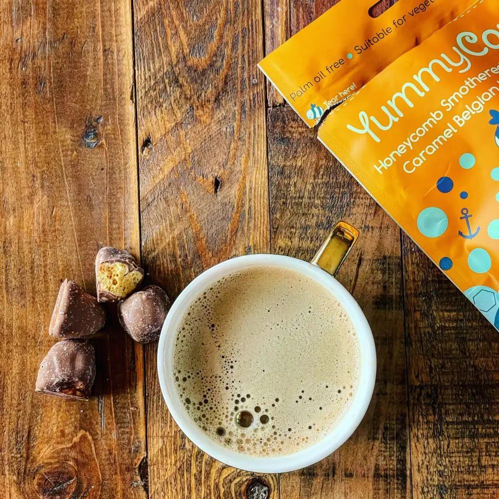 Yummycomb Salted caramel honeycomb bites covered in premium ml Belgian chocolate paired with a coffee on a bakers table